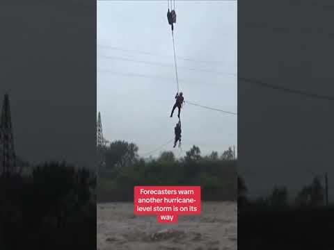 Rescue workers save a man from his car as China is hit by one of the worst typhoons in years