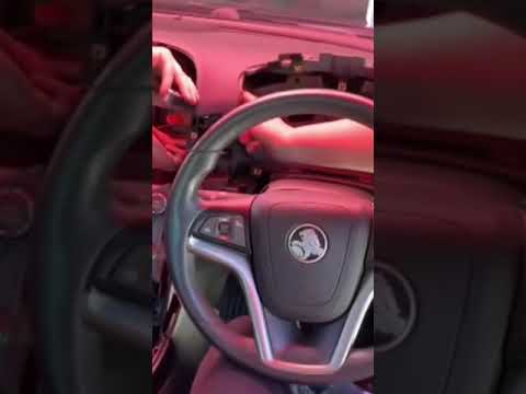 A rescue crew dismantle a car dashboard in search of a kitten