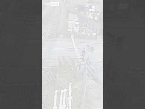 Man crosses railway tracks as train approaches