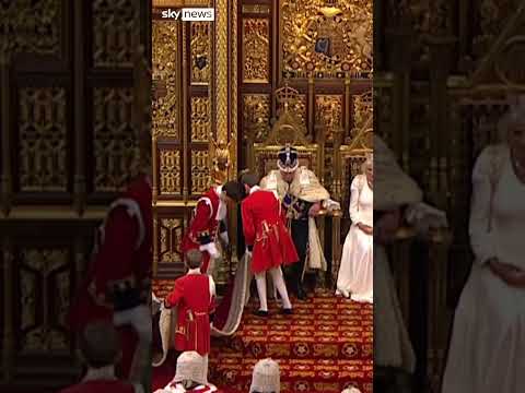 Moment page boy adjusts King’s robe