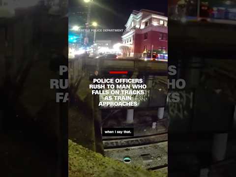 Police officers rush to man who falls on tracks as train approaches