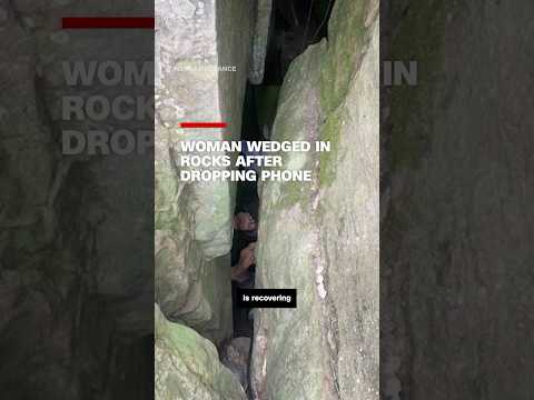 Woman wedged in rocks after dropping phone
