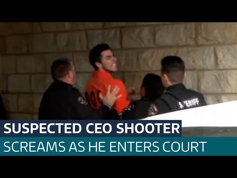 Man charged with killing CEO screams at cameras as he’s taken into court| ITV News