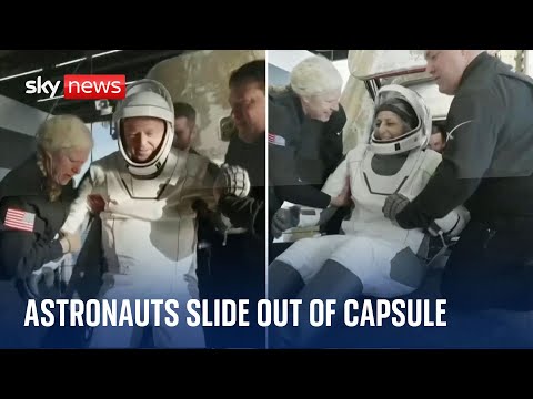 Two astronauts stuck in space for nine months exit the Dragon Freedom capsule