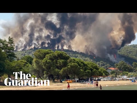Beachgoers on Greek island watch wildfire burn after intense heatwave