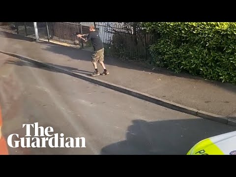 Footage shows man with a crossbow chasing police officers
