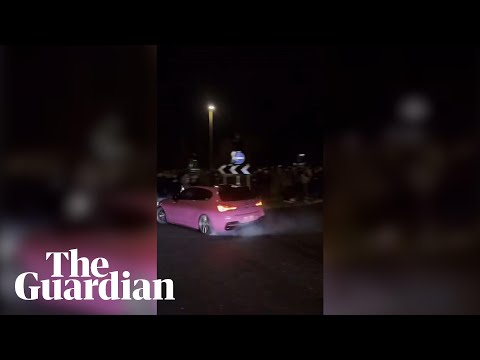 Driver drifts around a roundabout at an illegal car meet