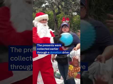 Santa Claus sweeps down from bridge to deliver gifts in Guatemala