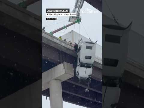 Driver rescued from truck dangling from side of bridge as heavy snowfall hits US