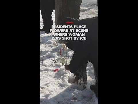 Residents place flowers at scene where woman was shot by ICE