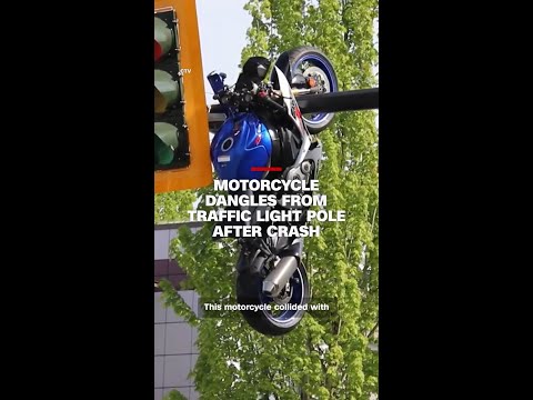 Motorcycle dangles from traffic light pole after crash