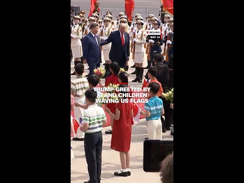 Trump greeted by Xi and children waving US flags