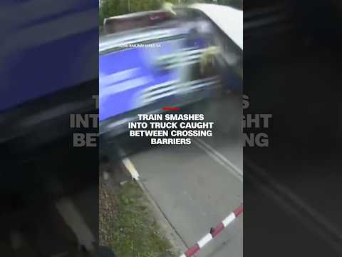 Train smashes into truck caught between crossing barriers
