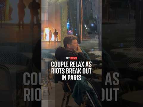 Couple relax as riots break out in Paris